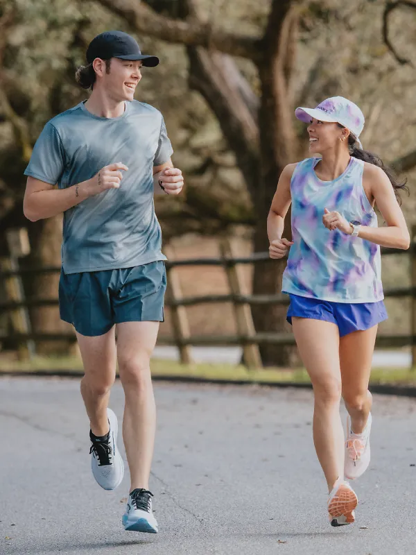 a man and a woman running side by side outside looking at each other