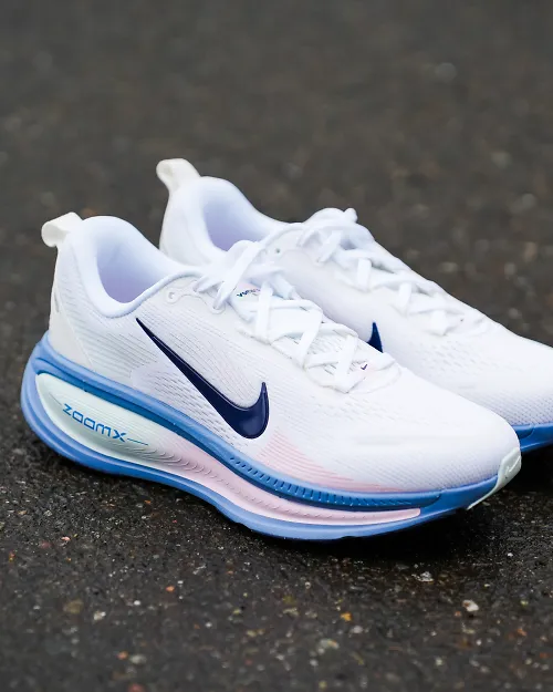 a pair of pink nike shoes on blacktop outside