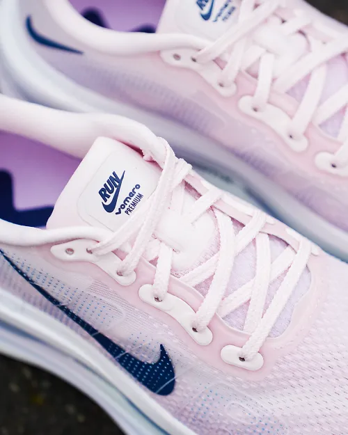 close up view of a pair of pink nike shoes on blacktop outside